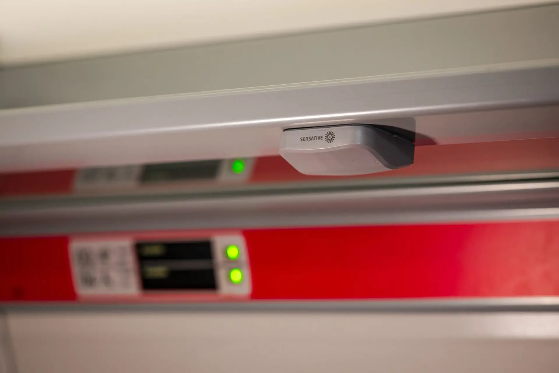 SeatSense radar sensor mounted under the luggage rail above train seats